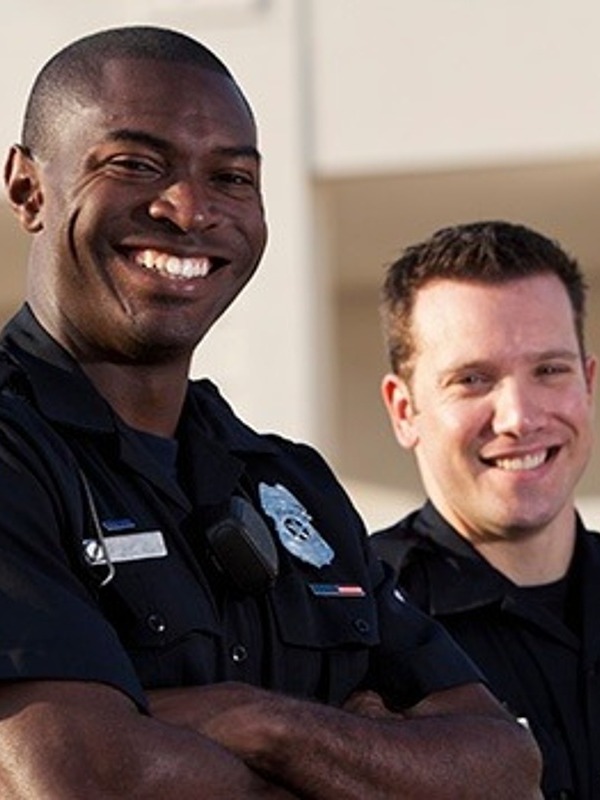 two police officers smiling at the camera