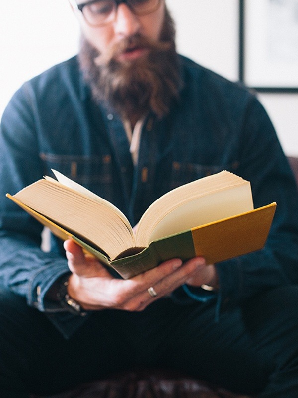 male christian counselor reading a book and leading a bible study